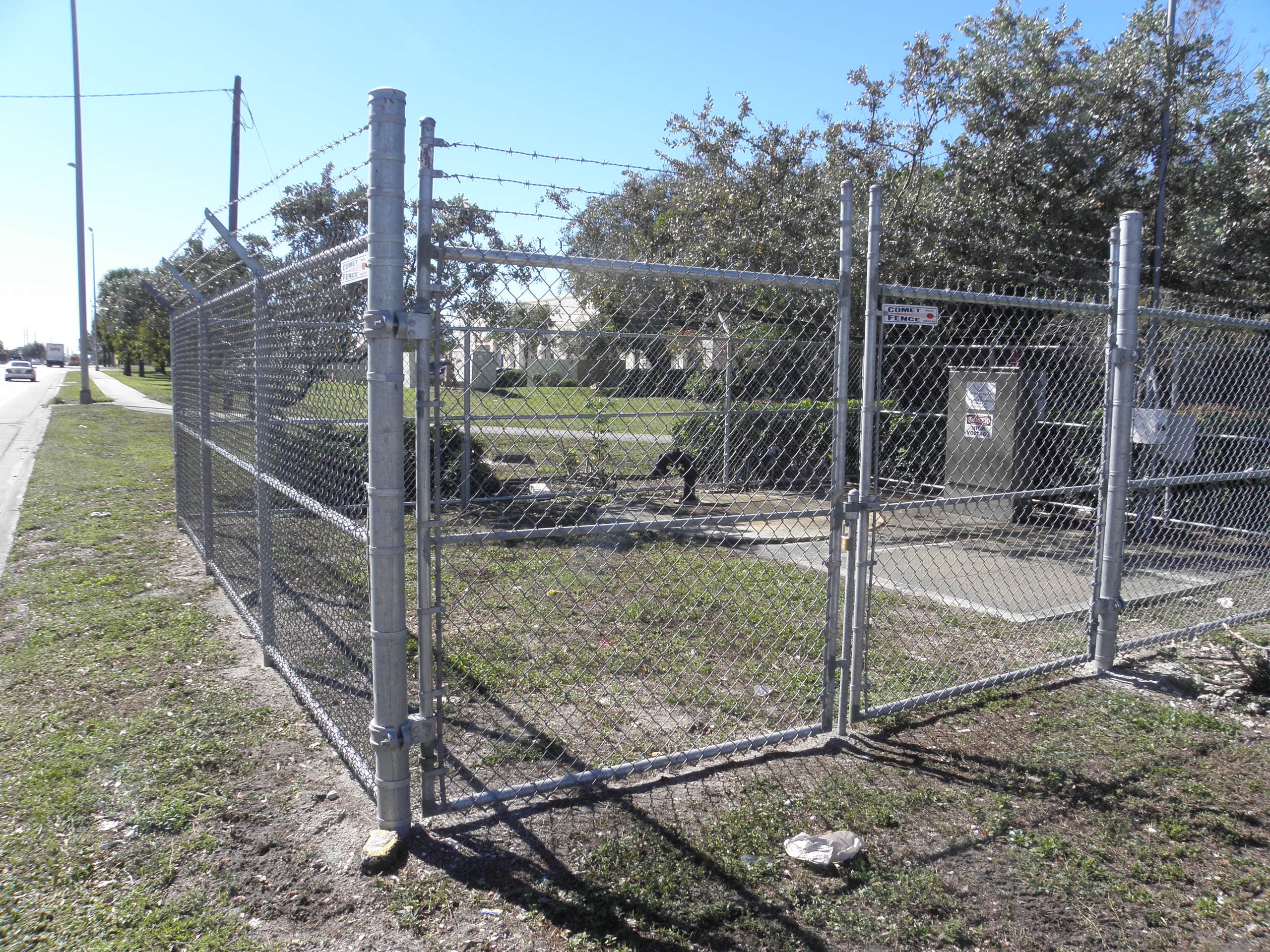 Chain link perimeter fence beside a building with clear sky