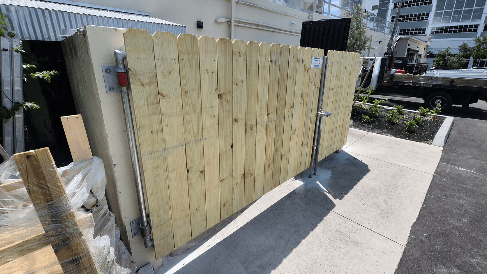 Single wood privacy gate with dog-ear pickets at a commercial utility area