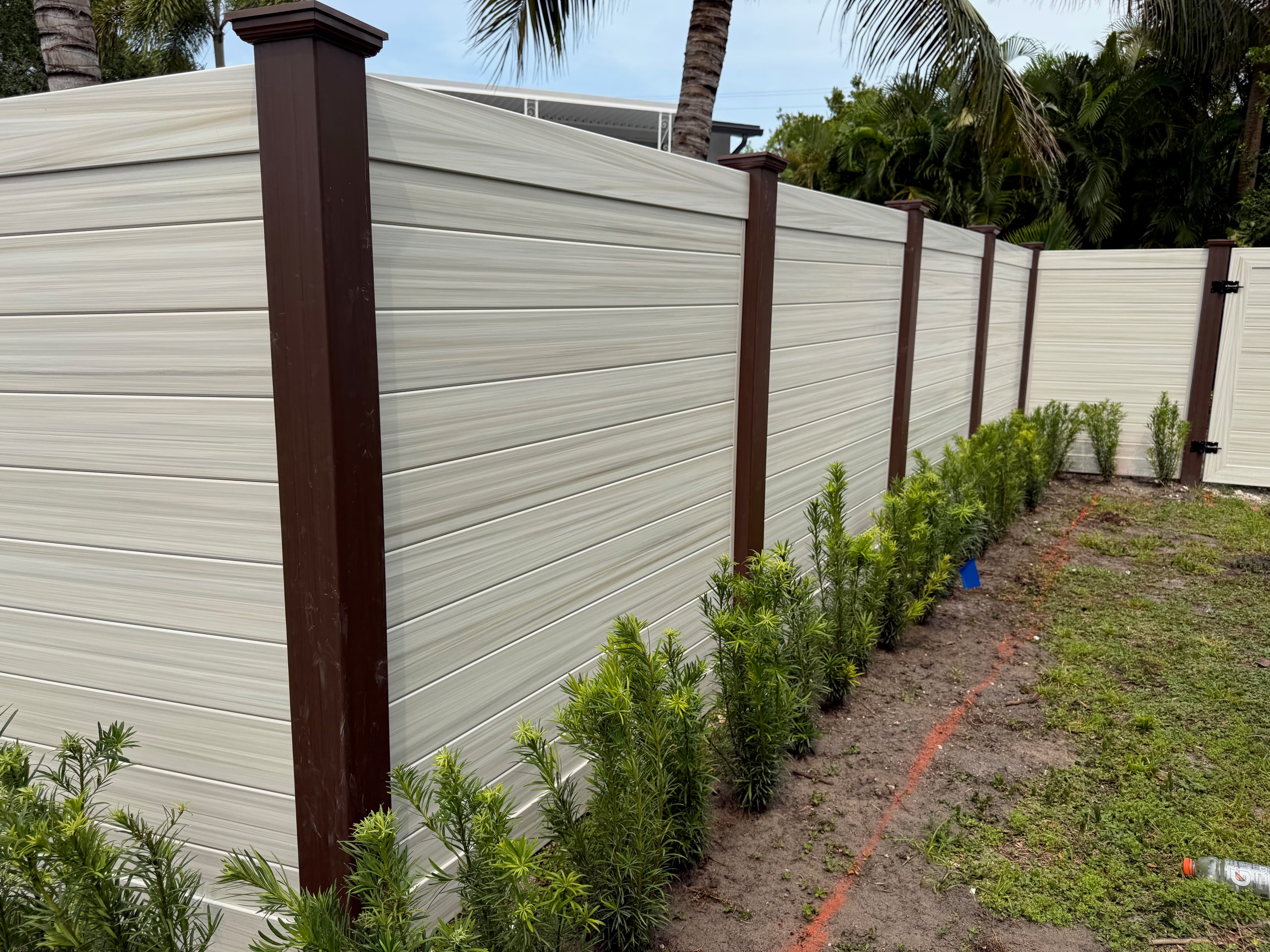Horizontal privacy fence corner with matching walk gate and fresh landscaping