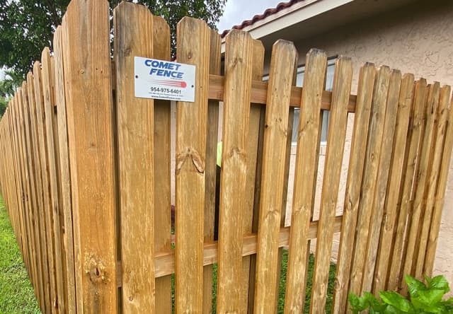 Wood privacy fencing along pool and landscaped backyard at a South Florida home
